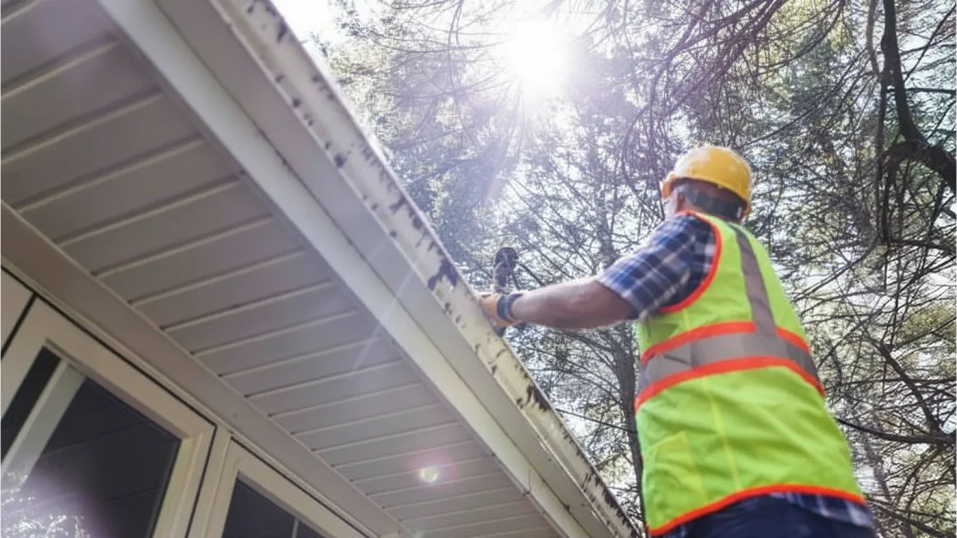 Roofing inspector on a residential roof examining shingles and flashing